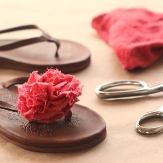 A pair of DIY fabric flower-decorated flip-flops.