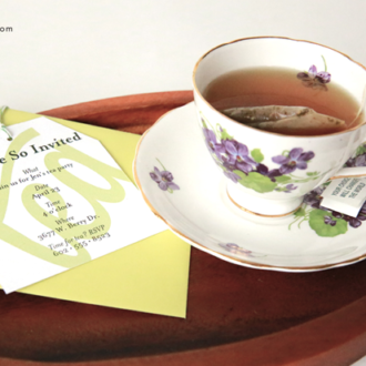 An easy DIY tea party invitation next to a cup of tea