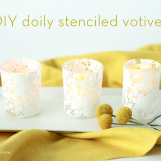A trio of DIY doily stenciled glass votive candle holders.