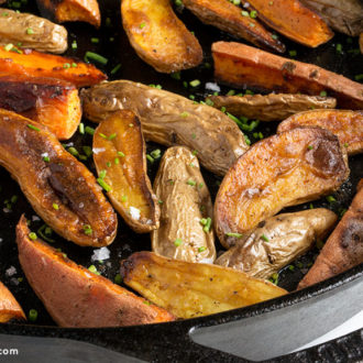 Roasted fingerling and sweet potatoes in a skillet and ready to serve as a side for dinner.