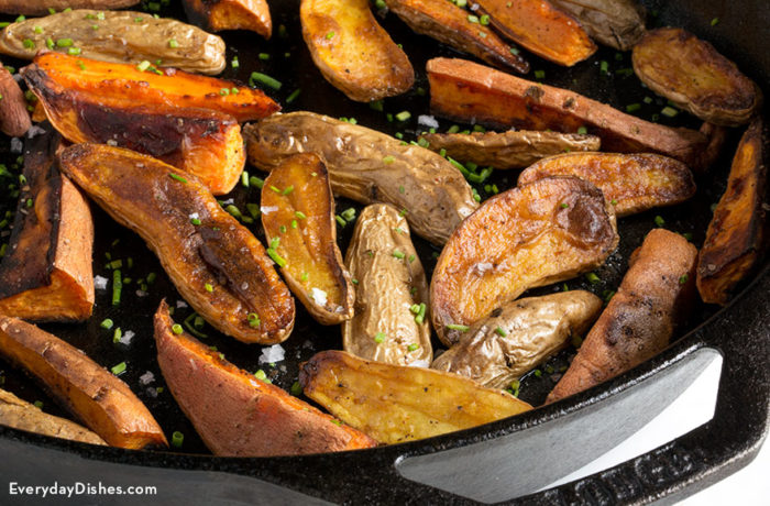 Roasted fingerling and sweet potatoes in a skillet and ready to serve as a side for dinner.