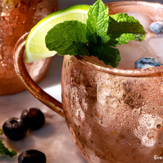 A mug with a blueberry Moscow mule cocktail.