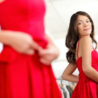A woman trying on a red dress, which is one of our favorite Valentine's Day looks, for under $100.