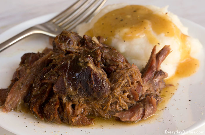 A plate of slow cooker beef roast with a side of mashed potatoes — the perfect dinner.
