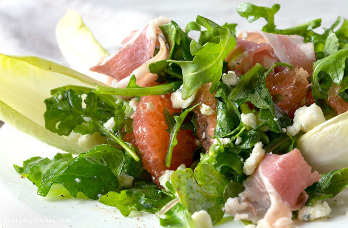 Arugula grapefruit salad with blue cheese, in a bowl and ready to enjoy.