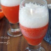 Two glasses of a refreshing blood orange beer mimosa cocktail.