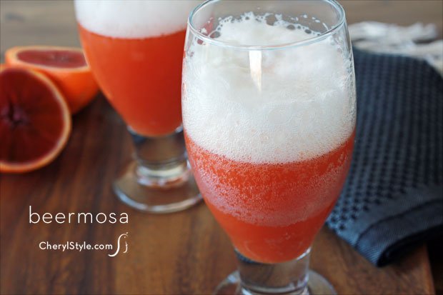 Two glasses of a refreshing blood orange beer mimosa cocktail.