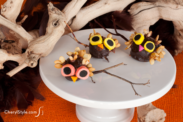 A batch of owl cake pops sitting on a plate.