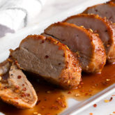 A juicy pork tenderloin, sliced up and ready to enjoy for dinner.