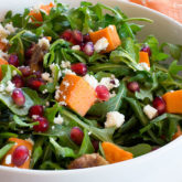 A bowl of delicious homemade arugula salad with citrus dressing.