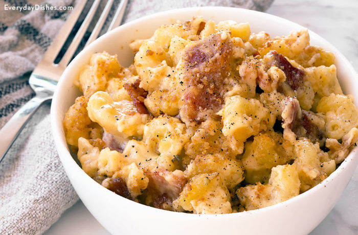 A bowl with a serving of homemade bacon mac and cheese casserole.