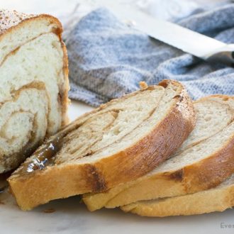 Freshly baked cinnamon swirl bread, partially cut into slices to serve.