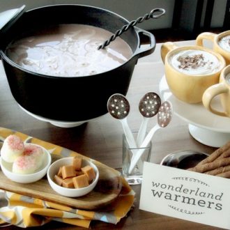 A hot chocolate bar with three full mugs and a range of toppings.