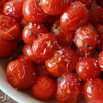 A bowl of oven-roasted grape tomatoes with basil & garlic — a clever way to dish up a refrigerator full of grape or cherry tomatoes!