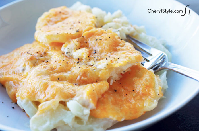 Peggy’s easy cheesy potato casserole made with real potatoes, on a plate and ready to enjoy for dinner.