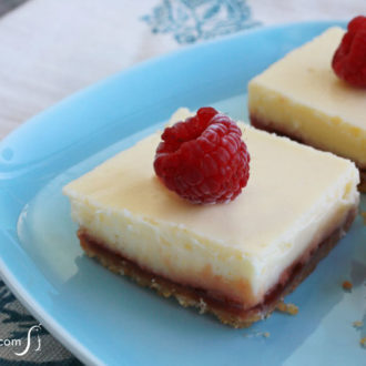 Easy-to-make raspberry lemon cheesecake bars with vanilla wafer crust, sliced into pieces and ready to enjoy for dessert.