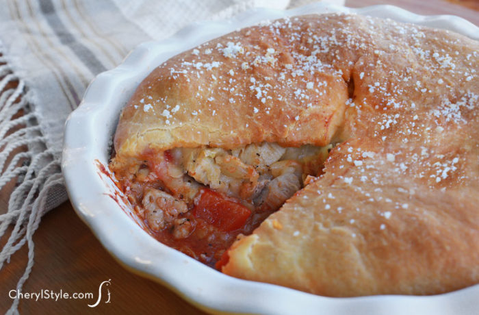A lean and hearty pizza pot pie with chicken and artichoke hearts, with a slice taken out.