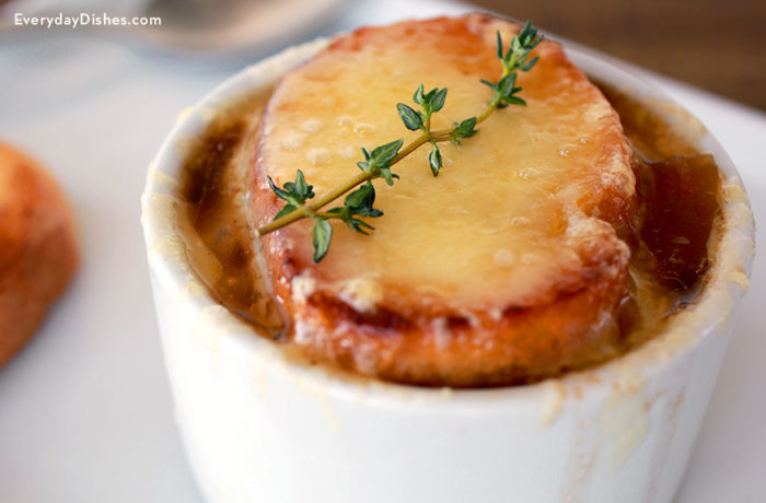 A cup full of French onion soup made in a slow cooker.
