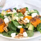 A plate of spinach and butternut squash salad.