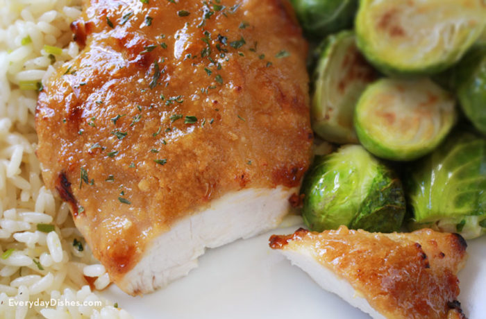 A plate of delicious sweet garlic glazed chicken served with rice and Brussels sprouts for dinner.