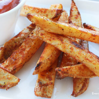 Homemade crispy baked fries with a side of ketchup.