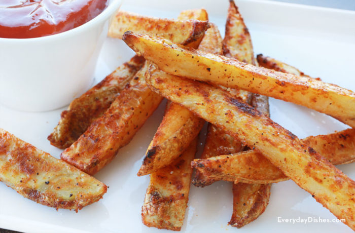 Homemade crispy baked fries with a side of ketchup.