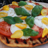 Grilled margherita pizza is crispy on the outside and chewy on the inside.
