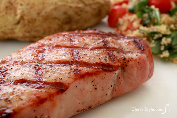 A thick and juicy pork chop that was made on the grill.