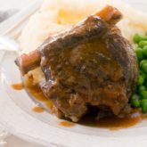 A dinner of slow cooker short ribs, mashed potatoes, and peas.