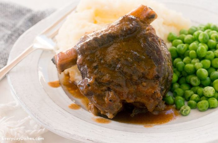 A dinner of slow cooker short ribs, mashed potatoes, and peas.