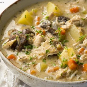 A bowl of homemade chicken soup with potatoes, carrots, and mushrooms — a great dinner on a cold night.