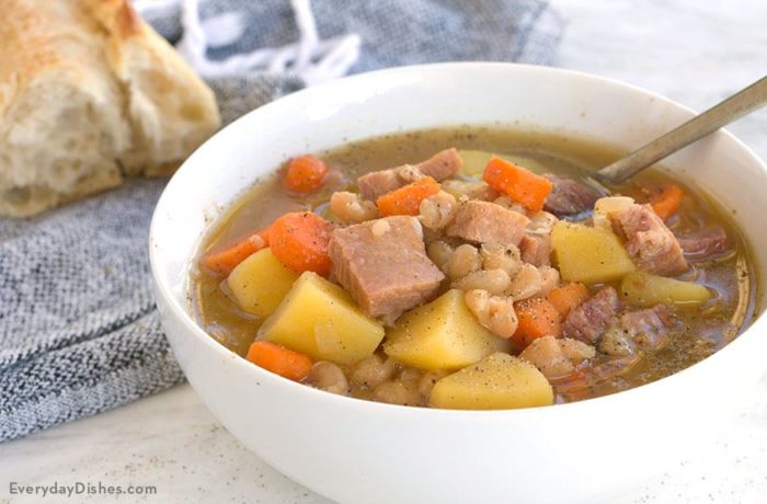 A bowl of ham and bean soup on the table and ready to eat.