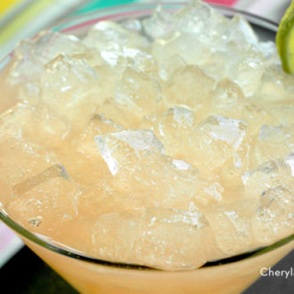 A glass full of a delicious Hemingway daiquiri, garnished with lime.