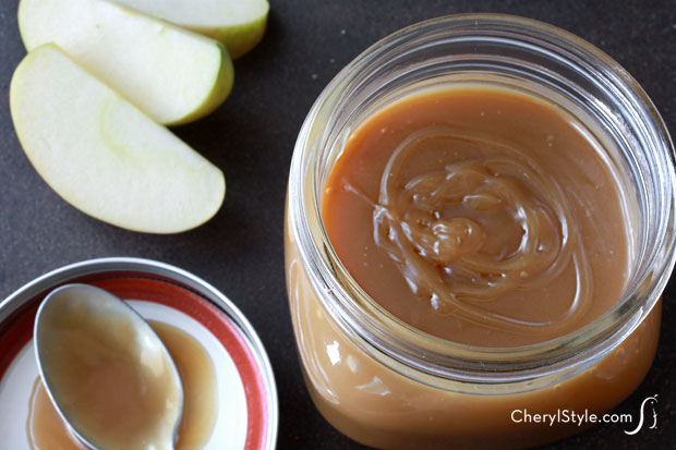 Fast and easy homemade butterscotch sauce topping in a jar, with some fresh fruit ready to be dipped into it.