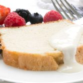 A slice of vanilla bean pound cake, surrounded by fresh fruit and ready to enjoy for dessert.