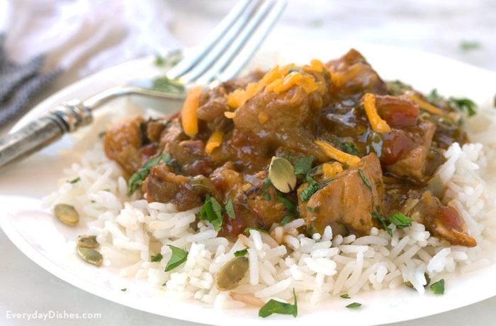 A plate of delicious Mexican green chili pork stew on a bed of rice.