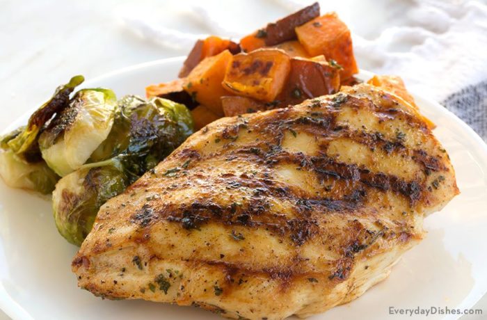 Moist grilled chicken, on a plate with a veggie side, a healthy and tasty dinner.