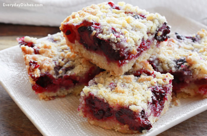 A batch of delicious blackberry crumb bars that are sliced into servings and ready to have for dessert.