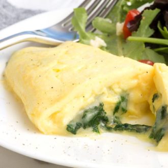 A delicate French omelet on a plate, sliced in half.