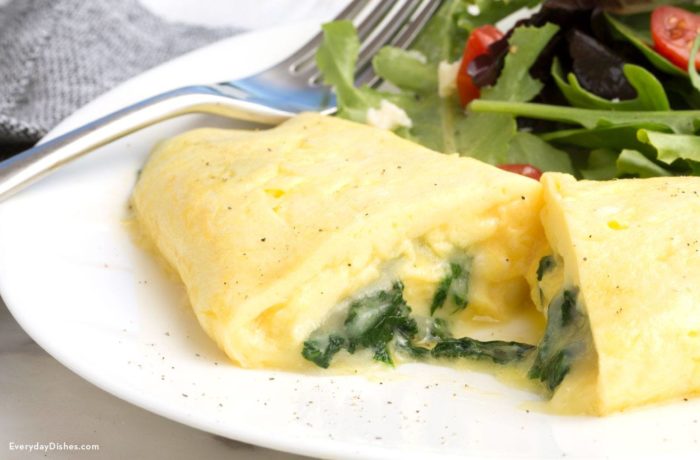 A delicate French omelet on a plate, sliced in half.