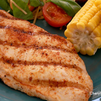 A piece of grilled chicken served with corn and salad — a healthy and tasty dinner.