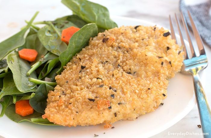 A plate with a serving of baked quinoa-crusted chicken served for dinner with a side salad.