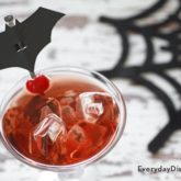 A tasty and spooktacular Halloween sour apple cocktail that's garnished with a bat.
