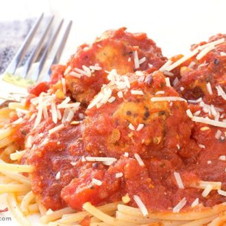 A plate of pasta topped with gluten-free turkey quinoa meatballs