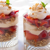 Two cups of layered strawberry pretzel salad.