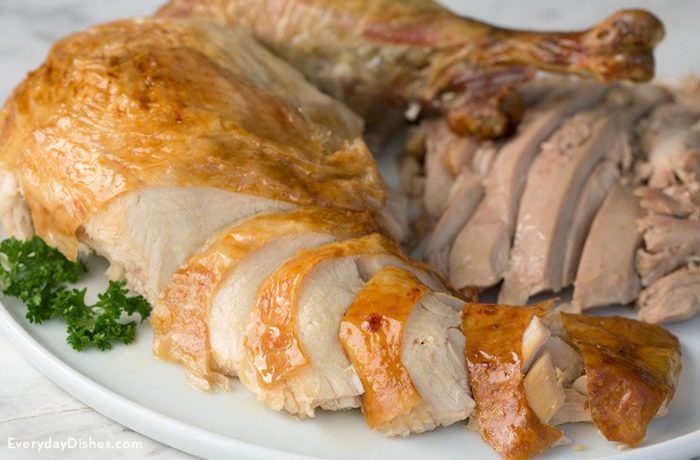 A plate with a sliced, moist Thanksgiving turkey.