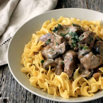 Delicious slow cooker beef stroganoff served on a bed of pasta.
