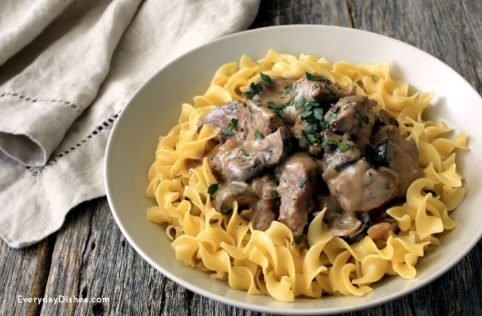 Delicious slow cooker beef stroganoff served on a bed of pasta.