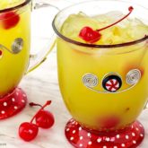 Two mugs of delicious Grinch punch, garnished with cherries.