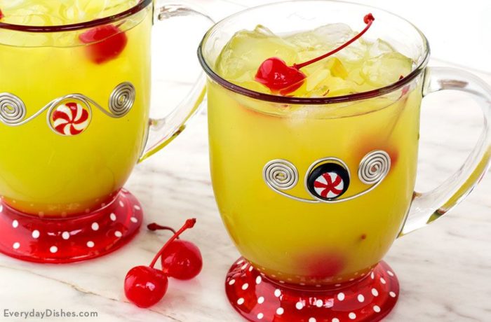 Two mugs of delicious Grinch punch, garnished with cherries.